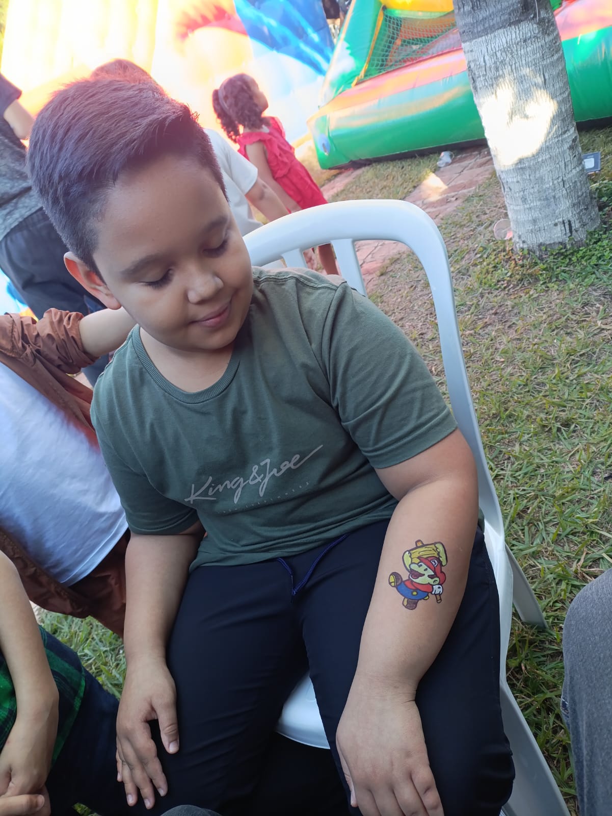 Menino exibindo pintura facial no braço em festa